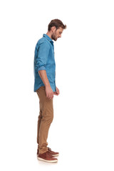 Poster - side view of a casual man looking down at something