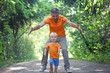 © Gargonia - Father play with his little son in summer park. Boy runs away, and his dad catches him. Family look clothing
