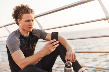 Portrait of a handsome sportsman sitting on a fitness mat