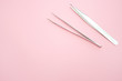 tools for Eyelash Extension Procedure. Two tweezers on pink background. copyspace mockup - Beauty and fashion concept