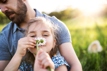 Father with a small daughter having fun in spring nature.