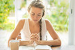 © PhotoGranary - Christian worship and praise. A young woman is reading the Bible and praying in the early morning