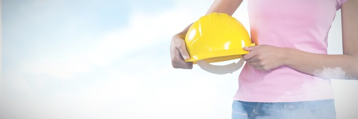 Poster - composite image of woman holding hard hat against grey