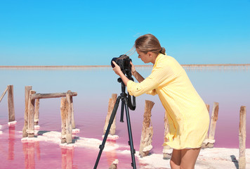 Wall Mural - Professional photographer taking photo of pink lake on sunny day