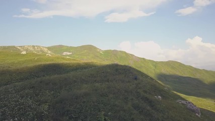Wall Mural - beautiful landscape hikers walking on green meadow in mountain aerial view