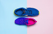 Blue mens and violet-pink female sneakers on pastel pink and blue background flat lay top view with copy space. Sports shoes, fitness, concept of healthy lifestile, everyday training.