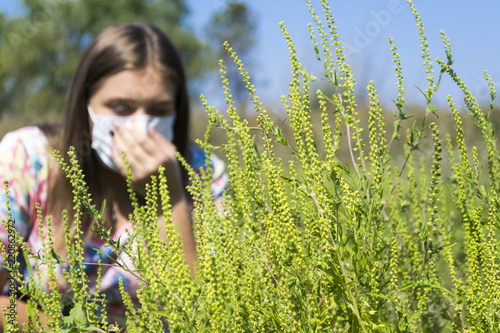 Young woman sneezes because of an allergy to ragweed. Poster Mural XXL