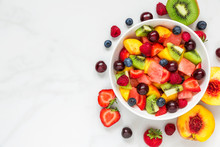 Bowl Of Healthy Fresh Fruit Salad On White Marble Background. Healthy Food. Top View