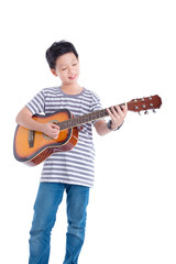 Wall Mural - Young asian boy playing guitar and smiles over white background