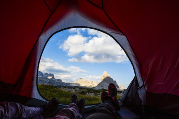 bivouac at tre cime di lavaredo, family resting in tent, red illuminated tent on pass in dolomites, 