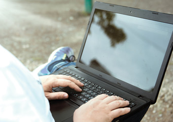 technology and communication, work at the keyboard with a laptop outdoors,