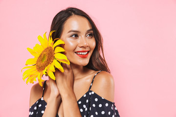 Poster - Smiling brunette woman in dress posing with sunflowers