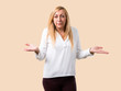 © luismolinero - Middle age blonde woman with white shirt unhappy and frustrated with something because not understand something. Negative facial expression on isolated ocher background