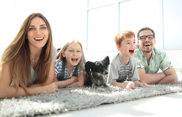 Wall Mural - happy family with two children lying in the new living room