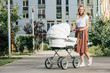 mother walking with baby stroller on street
