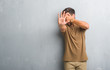 © Krakenimages.com - Handsome young man over grey grunge wall covering eyes with hands and doing stop gesture with sad and fear expression. Embarrassed and negative concept.