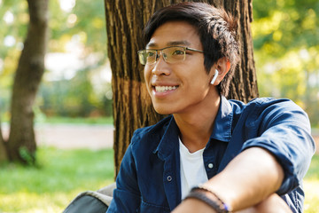 Wall Mural - Happy asian male student in eyeglasses looking away