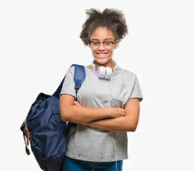 Young afro american student woman wearing headphones and backpack over isolated background happy face smiling with crossed arms looking at the camera. Positive person.