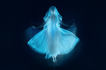 The photo as art - a sensual and emotional dance of beautiful ballerina through the veil on a dark background. A stroboscopic image of the one model