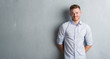 © Krakenimages.com - Young redhead business man over grey grunge wall with a happy and cool smile on face. Lucky person.