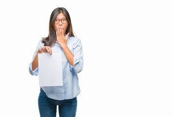 Sticker - Young asian woman over isolated background holding blank paper cover mouth with hand shocked with shame for mistake, expression of fear, scared in silence, secret concept