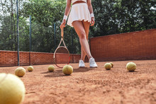 She Is The Best! Cropped Image Of Sexy Female Tennis Player On Outdoor Court. Sporty Young Woman With Tennis Racket And Several Tennis Ball On The Ground. Outdoors Exercises.