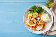 Grilled shrimps, parsley and lemon on blue wooden table. Top view. Copyspace