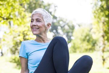 Wall Mural - Senior woman resing after workout in park