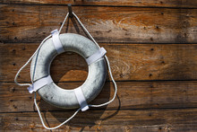 Old Lifebuoy On A Wooden Wall. Faded Ring Buoy. Copy Space For Your Text