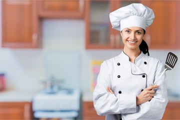 Wall Mural - Portrait of young woman chef on background