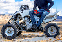 Helmeted ATV Rider Sitting On A Quad Bike In The Utah Desert