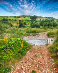 Wall Mural - Stony road and Mountain stream of water in the rocks with majestic blue sky