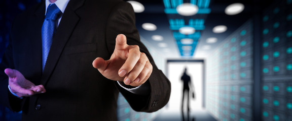 Poster - Businessman working with VR wide blank screen computer on server room in background.