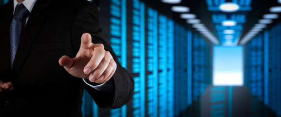 Poster - Businessman working with VR wide blank screen computer on server room in background.
