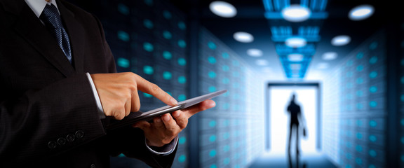 Poster - Businessman working with VR wide blank screen computer on server room in background.