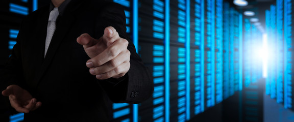 Poster - Businessman working with VR wide blank screen computer on server room in background.