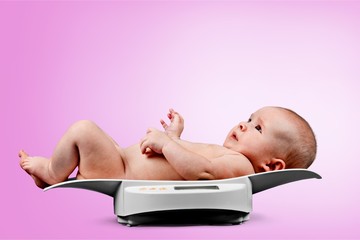 Sticker - Beautiful baby boy on on weighing scale