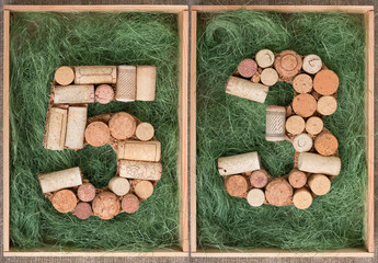 Wall Mural - Number 53 fifty three  made of wine corks on green background in wooden box