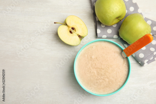 Fotografía Flat lay composition with bowl of healthy baby food and space for text on light