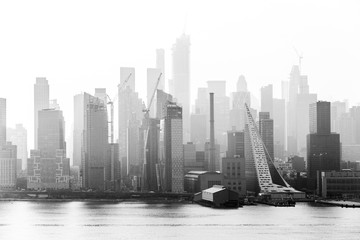 Fototapete - New York City midtown Manhattan skyline panorama view from Boulevard East Old Glory Park over Hudson River on a misty morning. Black and white image.