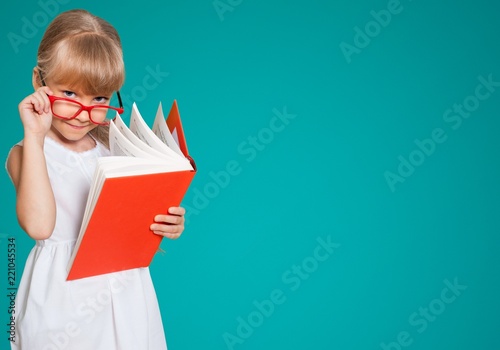 фотография Education and school concept - little student girl with book at