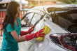 © geargodz - woman holding sponge to washing car