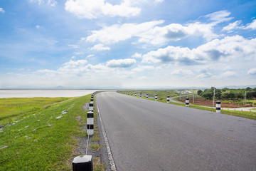 Landscape Scenic road travel on empty highway near a large reservoir with sky and clouds background.Pa Sak Jolasid Dam Thailand.