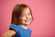 © Ilshat - Little girl with charming smile isolated on pink background.