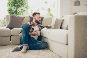 Online shopping concept. Concentrated man sitting on the floor w