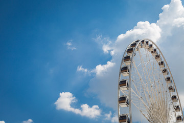 Wall Mural - White big Ferris wheel  with blue sky sharp clouds