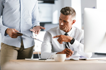 Fototapete - Image of adult director man 30s in formal clothes working on computer in office, and talking with employee