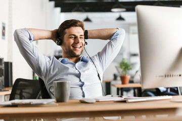 Wall Mural - Smiling office manager talking by headset with microphone