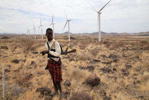 A Turkana herdboy carries his gun as he follows his goats near the ...