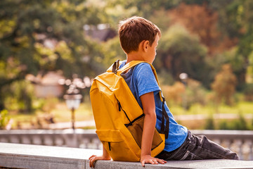 Wall Mural - Sad alone boy sitting in the park outdoors